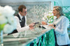 Man and woman at a reception desk with floral decorations. S.S. Catherine