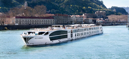 Cruise ship on a body of water with a cityscape in the background. S.S. Catherine