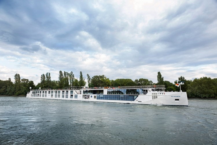 Passenger boat on a river with trees and clouds in the background