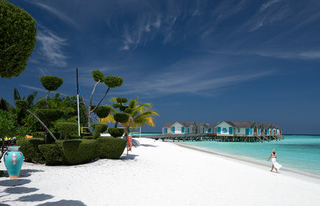 Beachfront with water villas and a clear blue sky