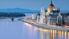 Evening view of a European city with a prominent building by a river