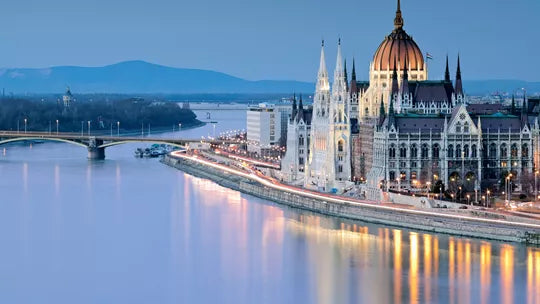 Evening view of a European city with a prominent building by a river