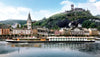 River cruise ship on a river with a town and castle in the background