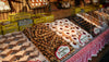 Display of various baked goods including cookies and pastries in a market setting.