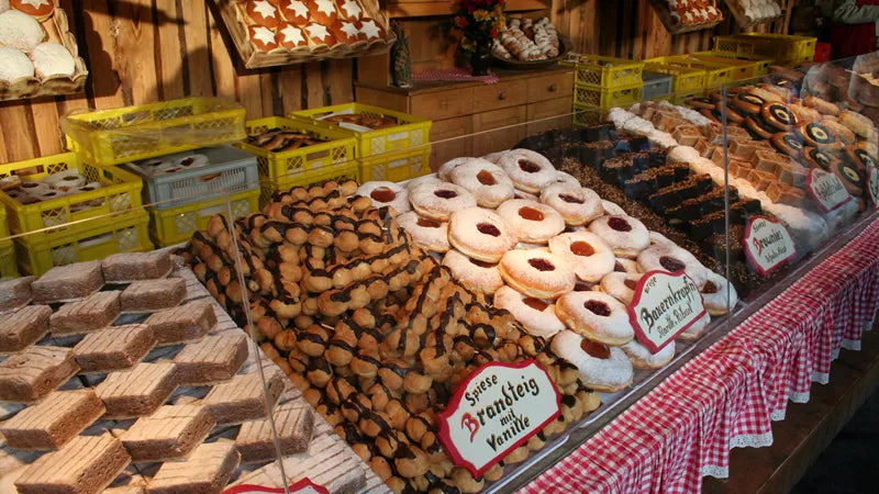 Display of various baked goods including cookies and pastries in a market setting.