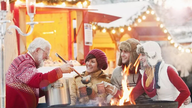 People gathered around a fire pit at a winter market.