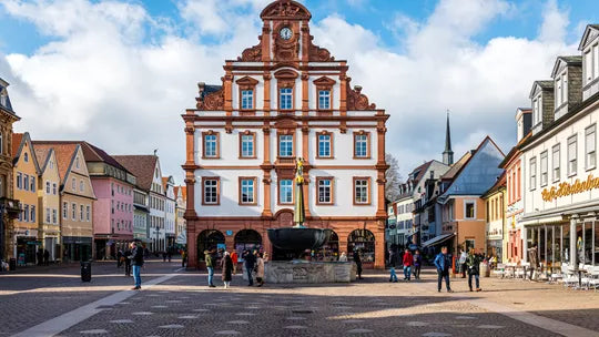 Town hall building in a European town square with people walking around.