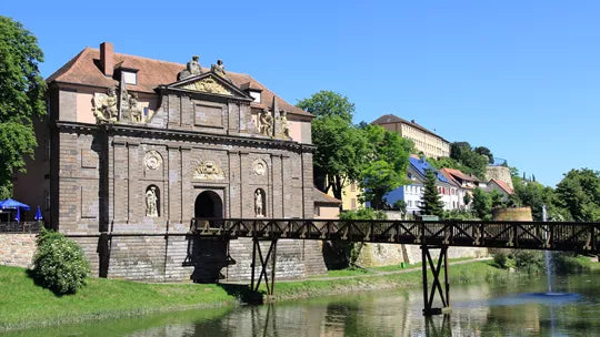 Historic stone building with decorative elements by a river