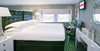 Modern hotel room with a bed, desk, and decorative elements.