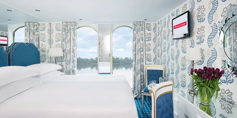 Modern hotel room with bed, television, and decorative elements.